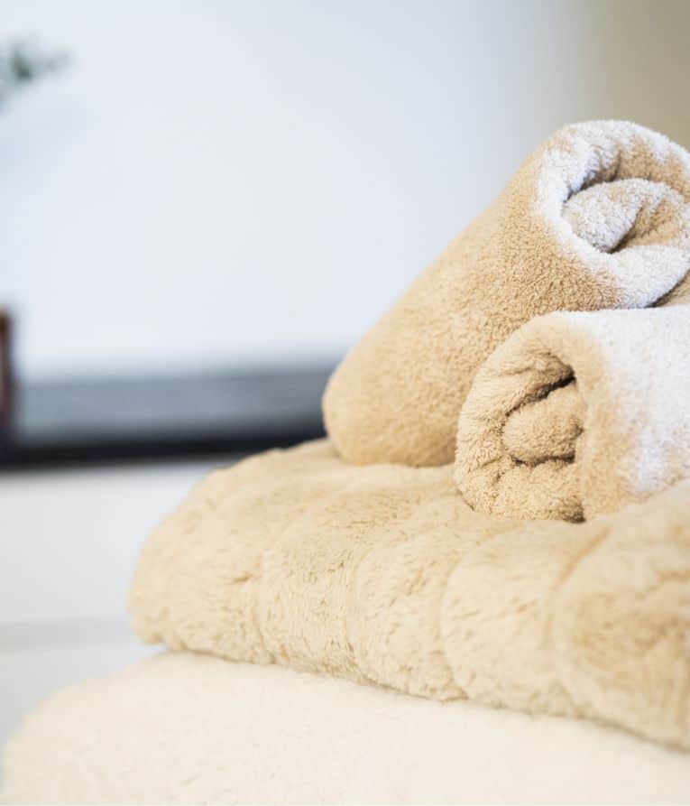 Detailaufnahme aufgerollter Handtücher – stilvolle Atmosphäre im Emé Cosmetic Studio Hannover